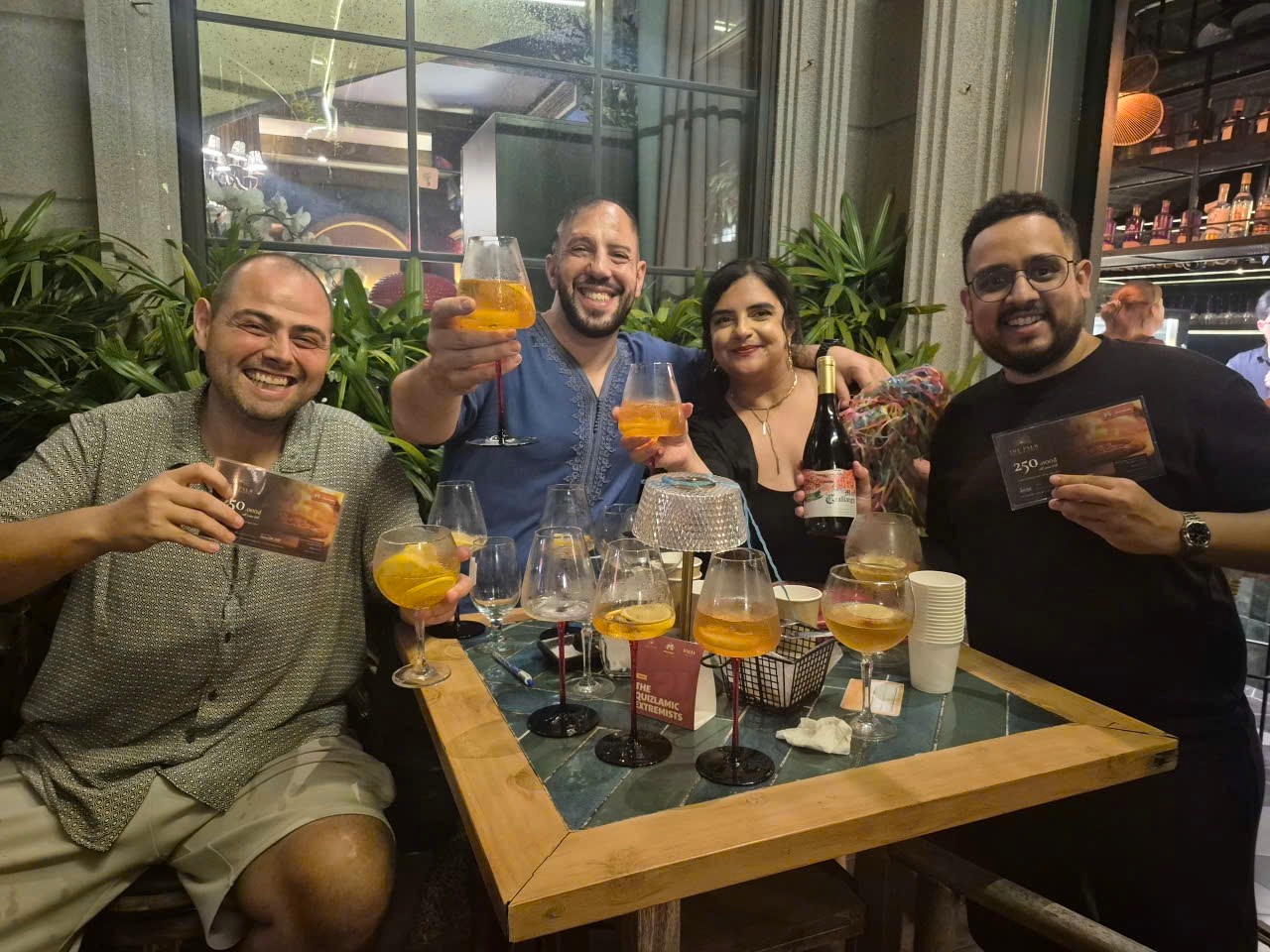 The Quizlamic Extremists, night one champions, raising their glasses at The Palm